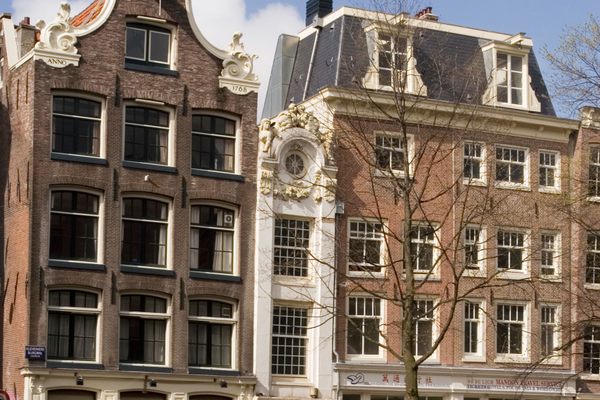 Row of old houses with the narrow Kleine Trippenhuis or “Little Trip House” on Kloveniersburgwal canal.